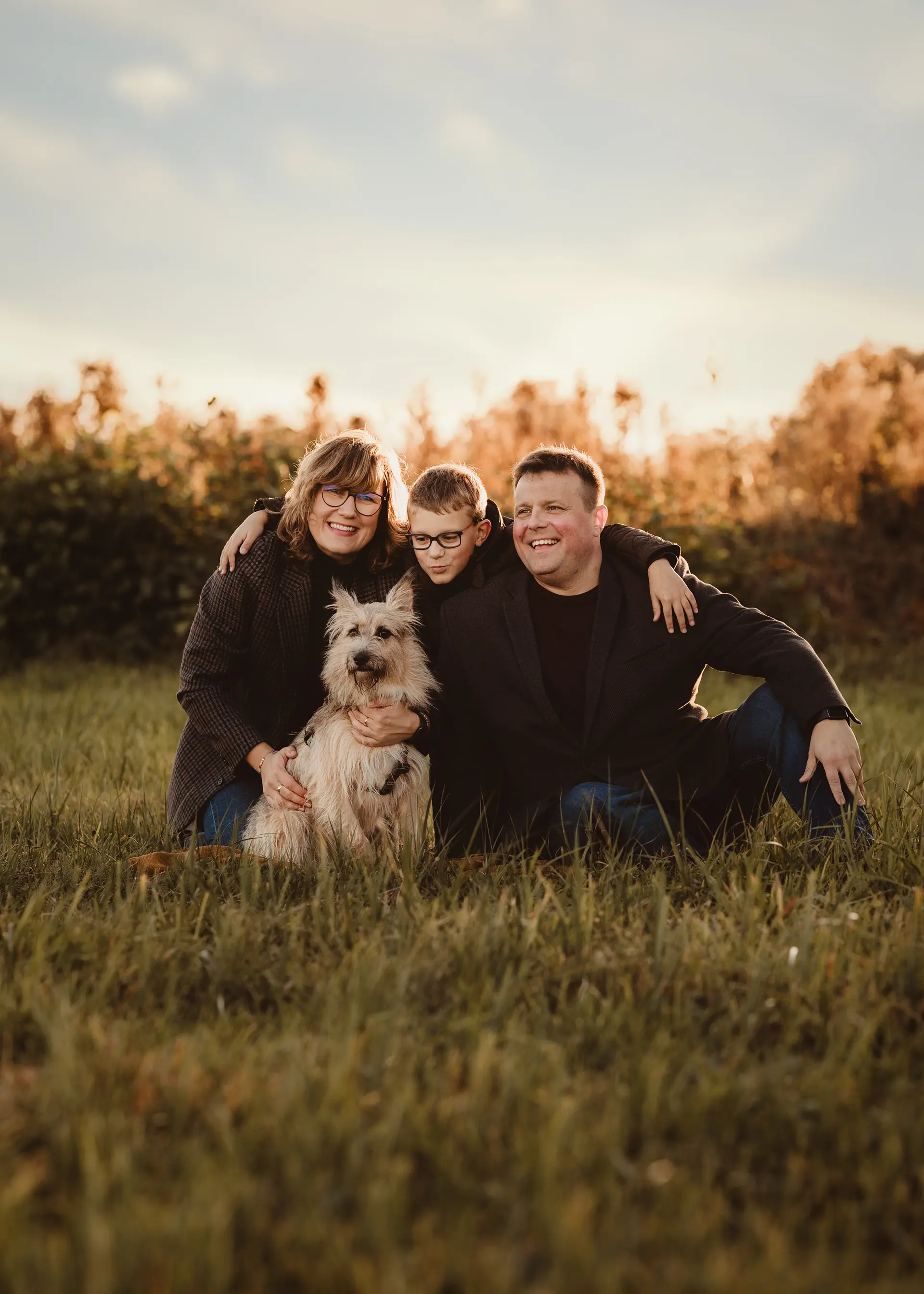 Radosna fotografia rodzinna Gdynia, fotograf o mnie prywatnie na łące z mężem, synem i psem