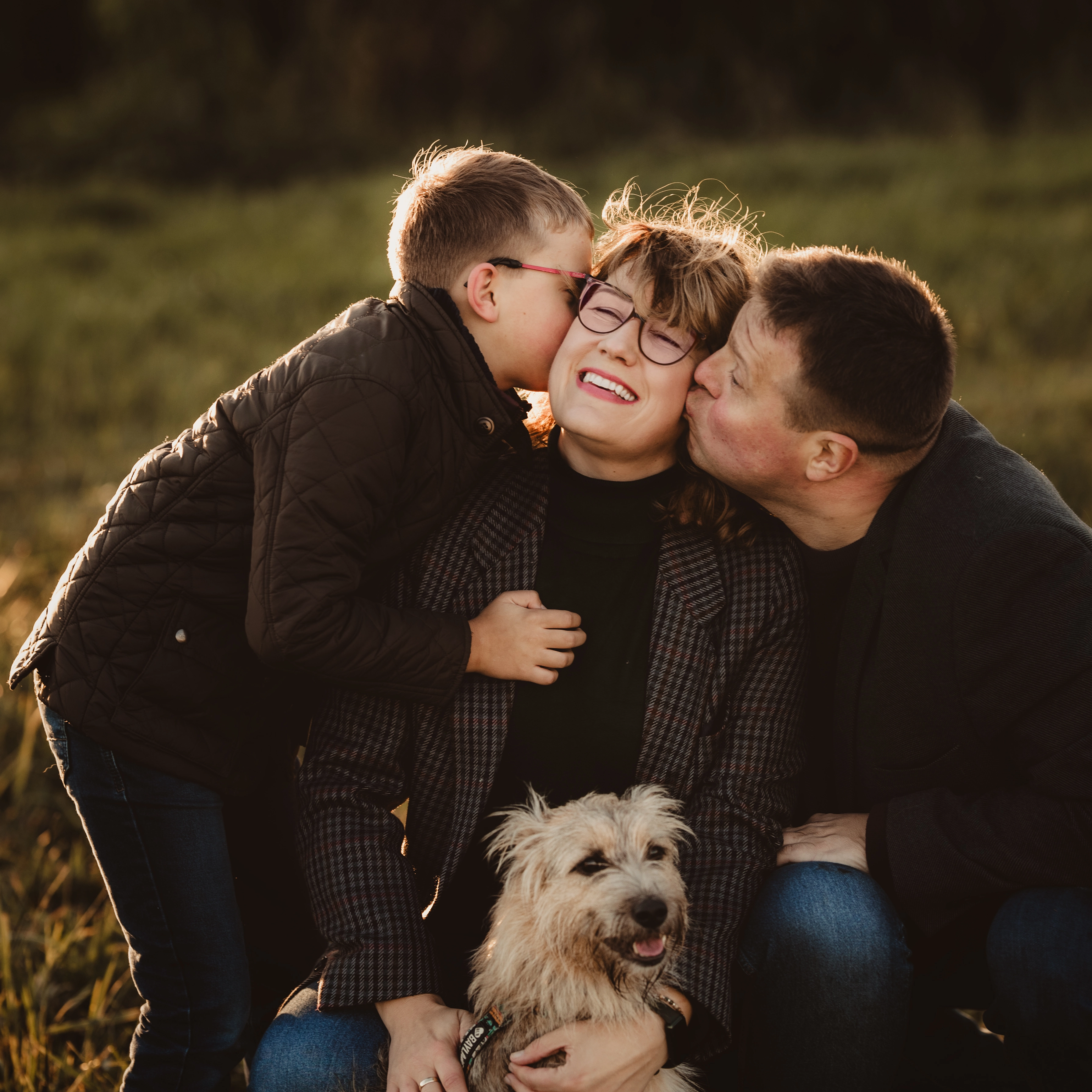 Czuły portret fotograf rodzinnej Gdynia z mężem i synem, całusy o zachodzie słońca na łące