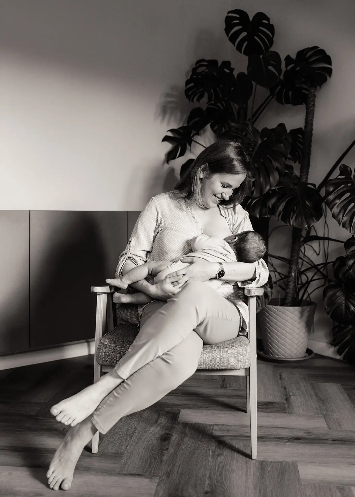Czarno-biała domowa sesja noworodkowa, mama Agnieszka karmiąca piersią Jerzyka w przytulnym salonie, naturalna fotografia lifestyle, Gdynia