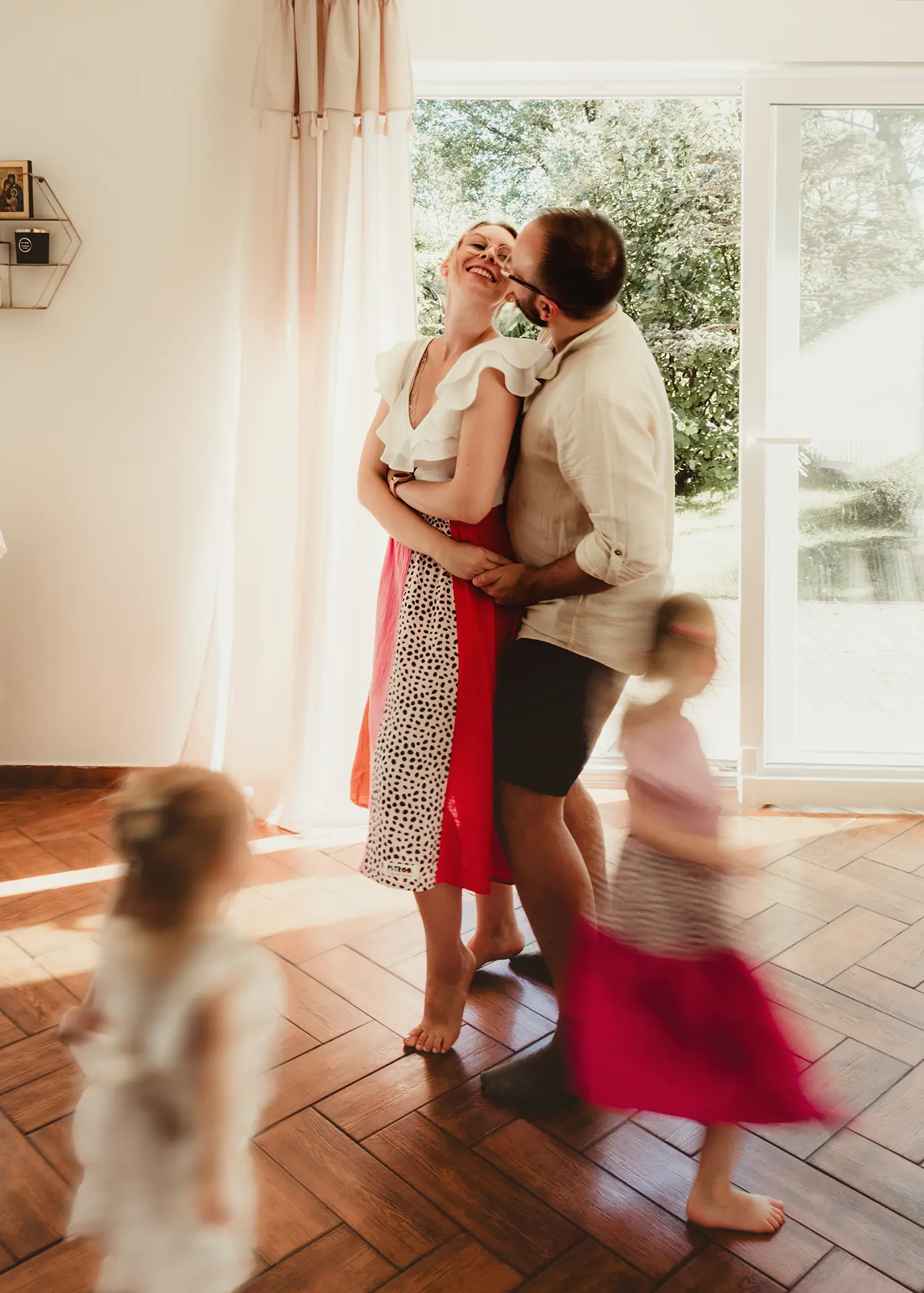 Dzieci bawiące się wokół przytulających się rodziców na białym tle, sesja w stylu skandynawskim