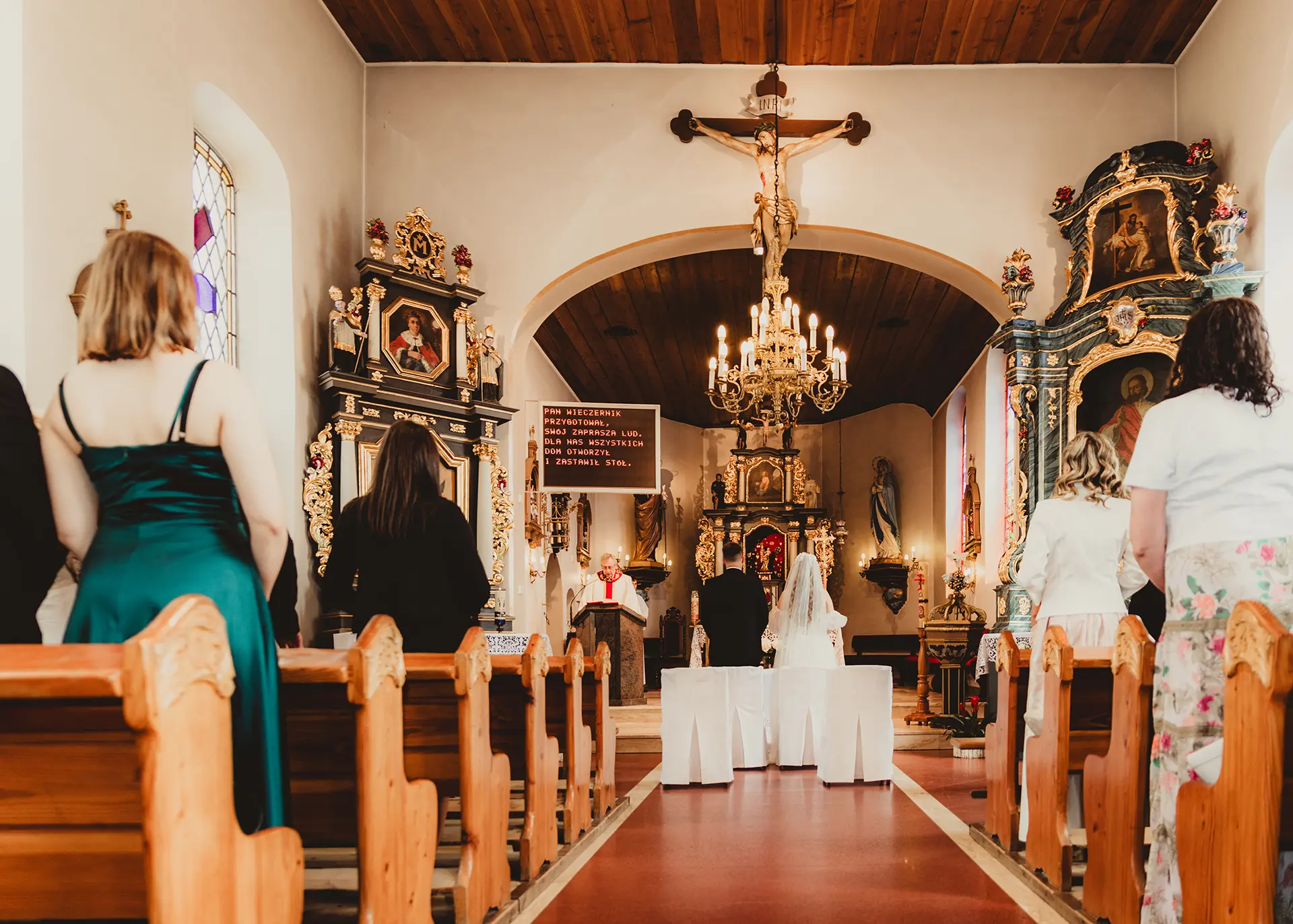 Ceremonia ślubna w kościele w Gdyni, młoda para przed ołtarzem, goście w ławkach, fotografia ślubna reportażowa