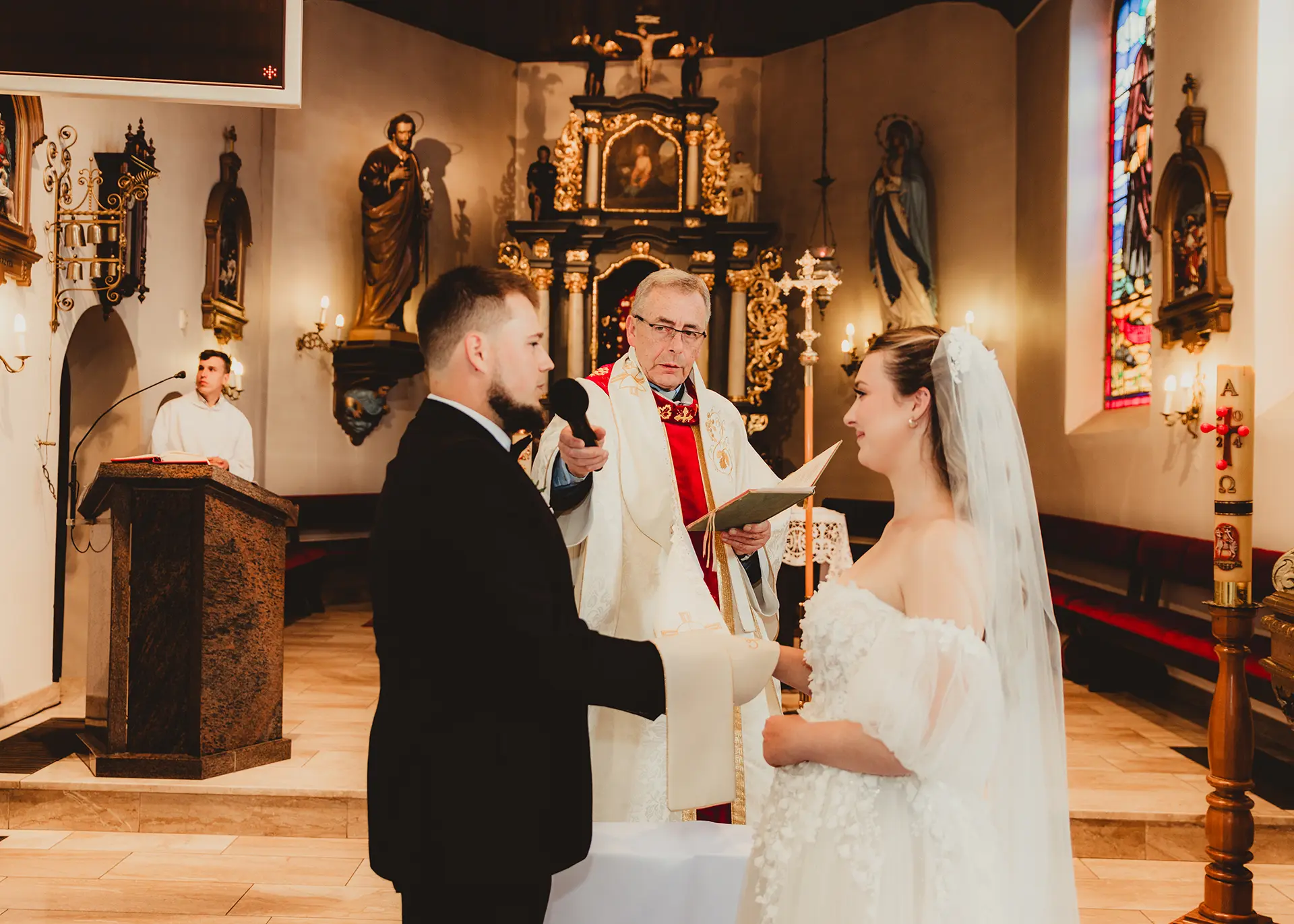 Zuzia i Nikodem składający przysięgę małżeńską, bliskie ujęcie emocji przed ołtarzem, fotograf ślubny